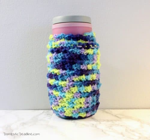 A crocheted coffee cozy to fit travel and disposable mugs. Keep your hands warm by tucking them inside the sleeve and hide a gift card or cash in the hidden pocket so you always have enough for a cup of coffee.