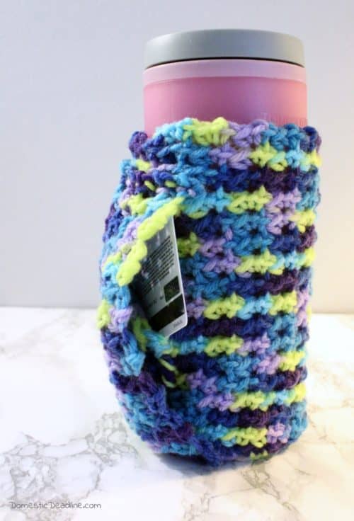 A crocheted coffee cozy to fit travel and disposable mugs. Keep your hands warm by tucking them inside the sleeve and hide a gift card or cash in the hidden pocket so you always have enough for a cup of coffee.